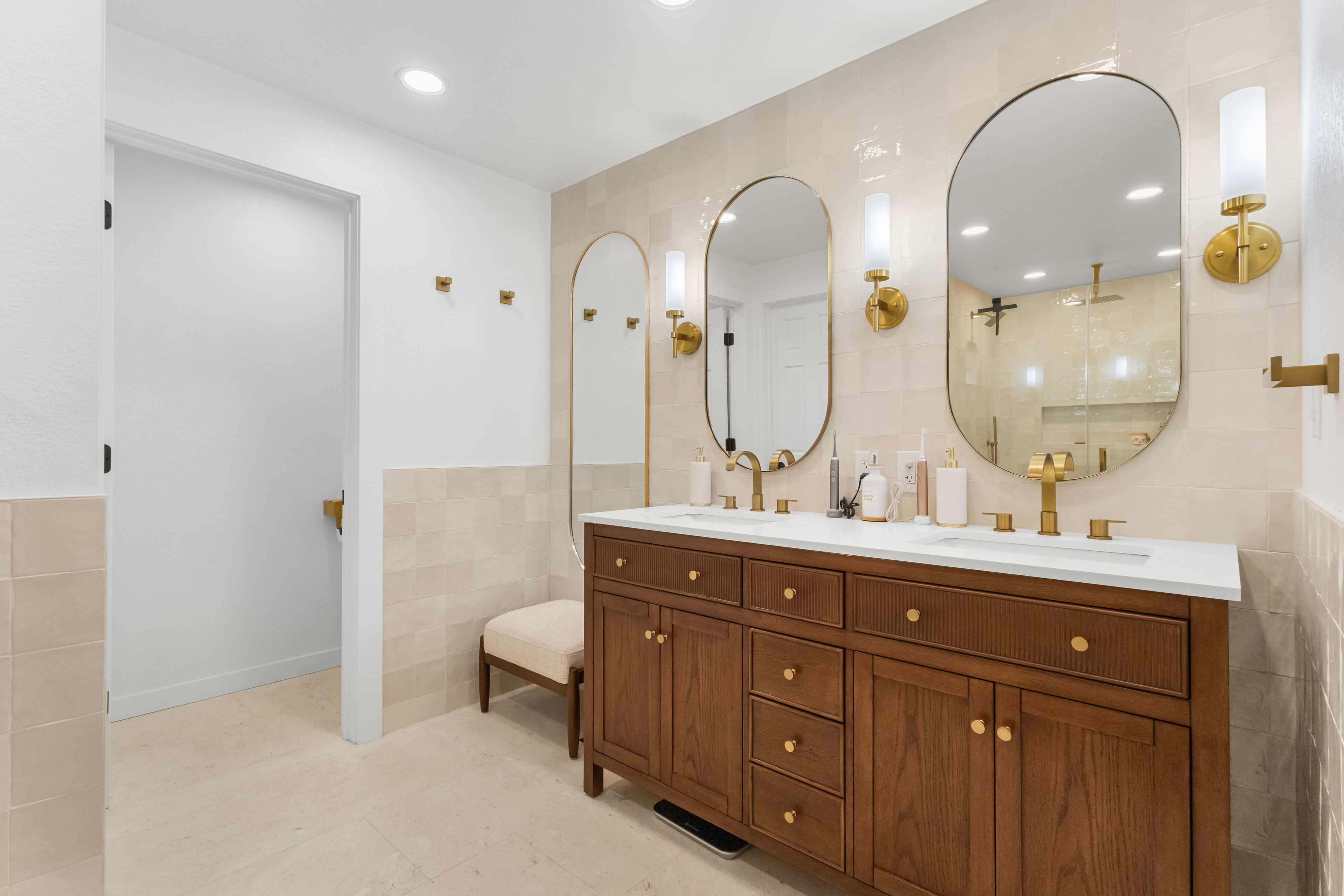 Eagle bathroom remodel — custom wood double vanity with brass mirrors and sconces