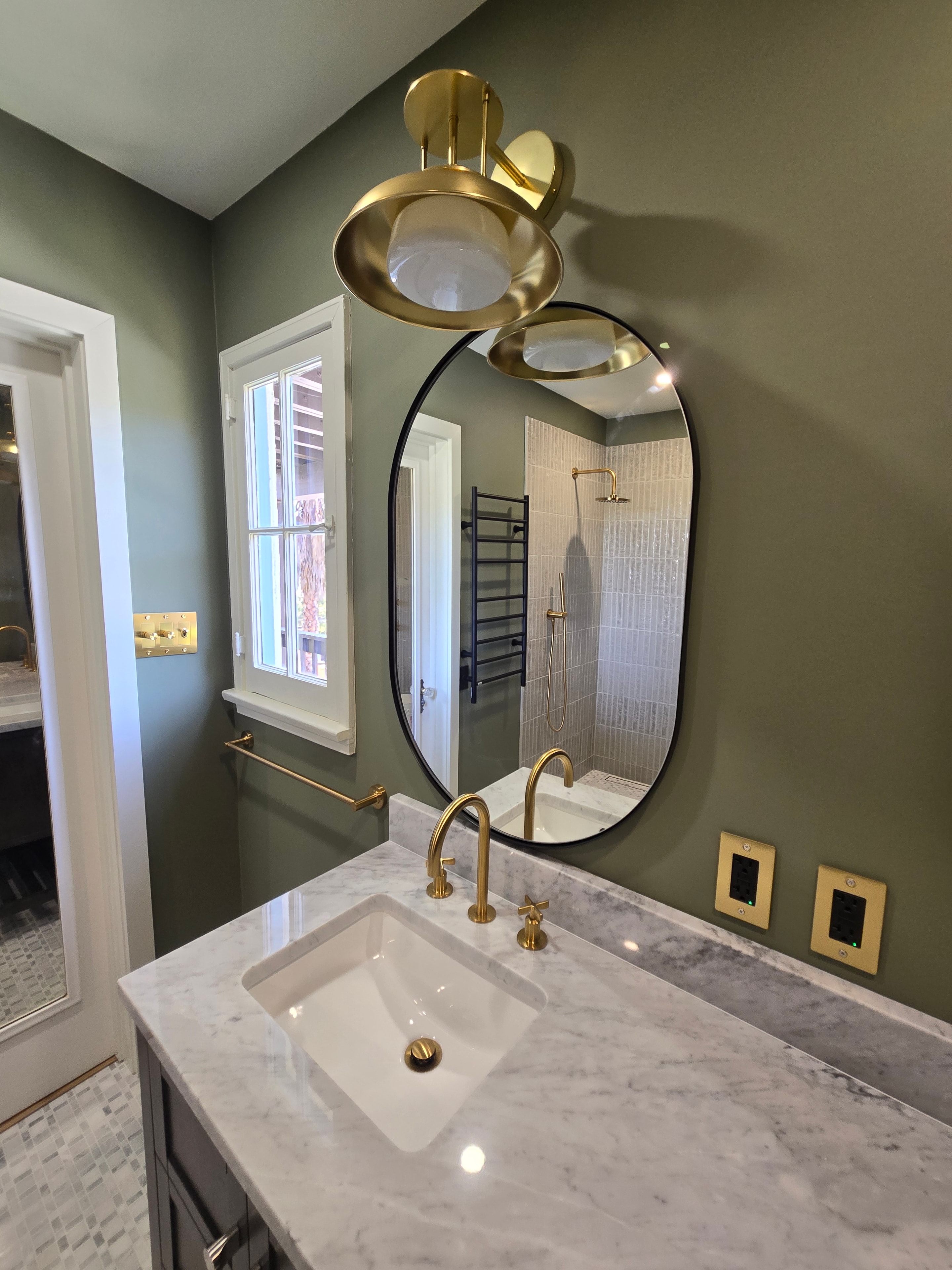 Bathroom remodel — vanity and oval mirror with brass sconces