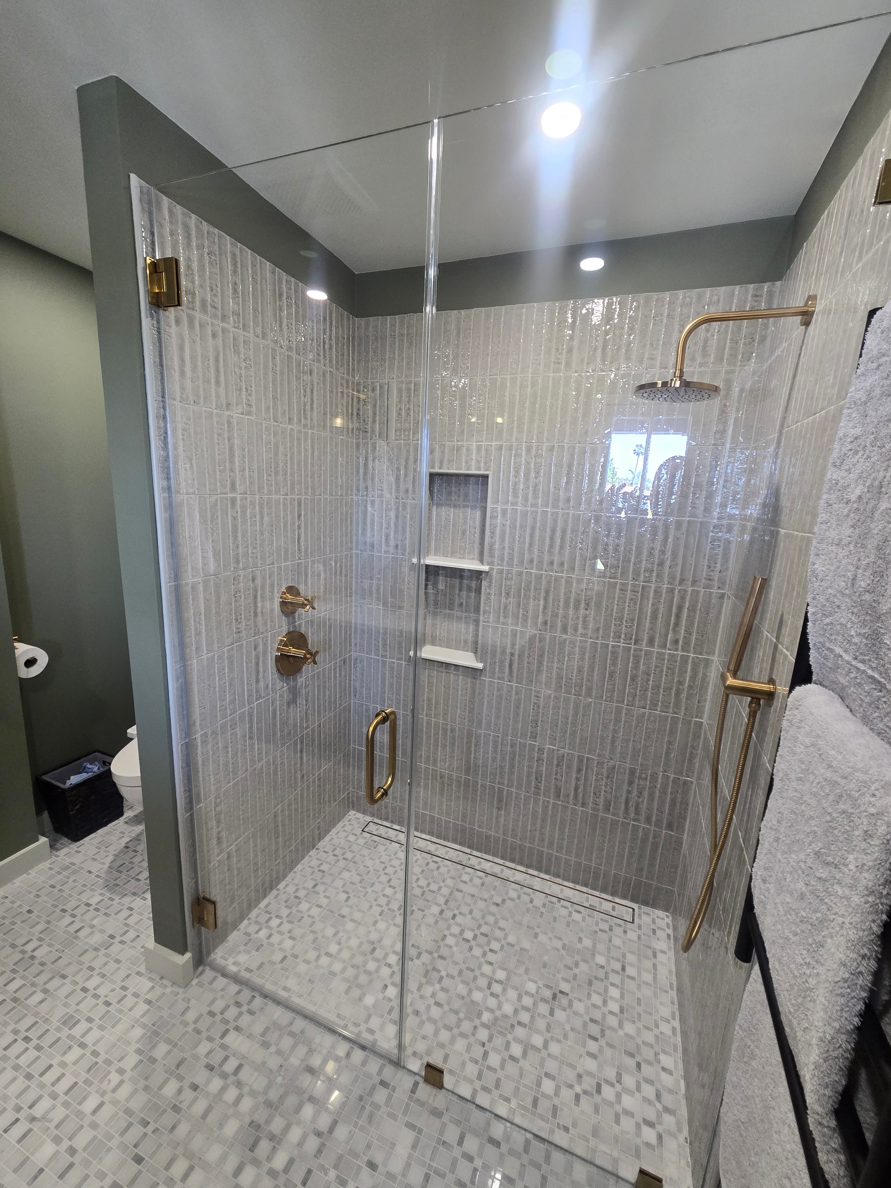 Bathroom remodel — custom tile shower with glass enclosure and brass hardware