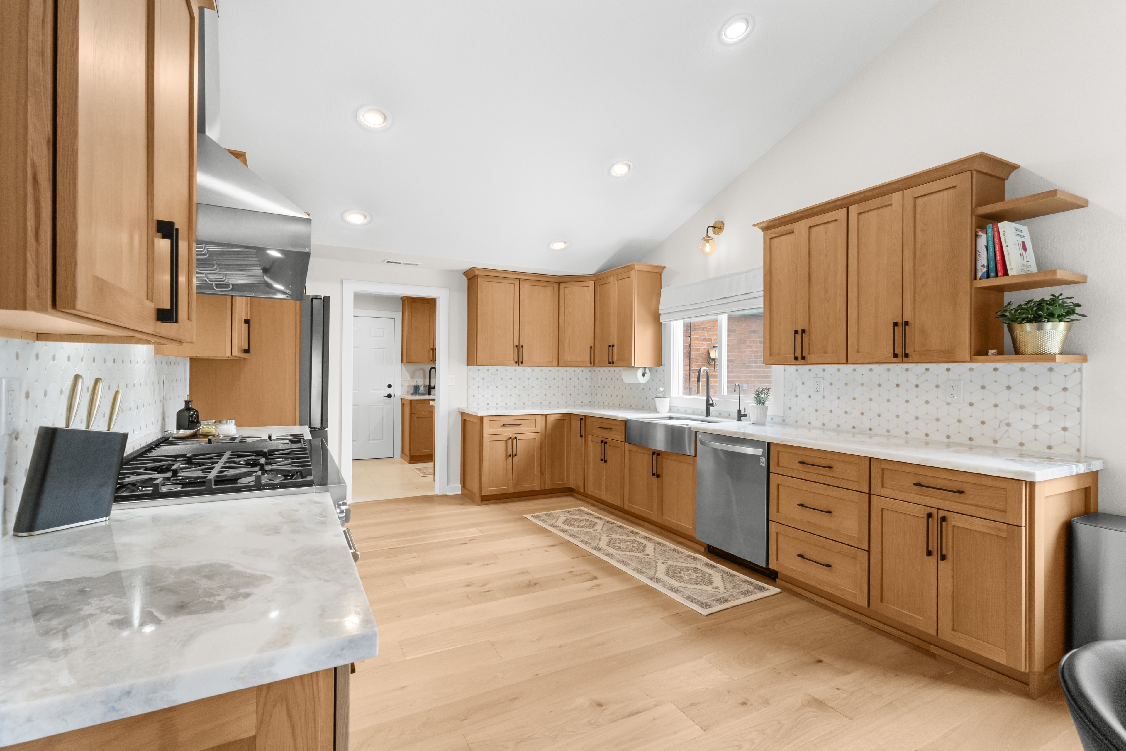 Kitchen remodel — full kitchen overview with marble countertops and open shelving